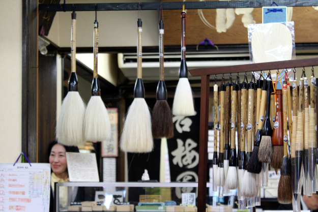 Calligraphy brushes hanging in a shop.